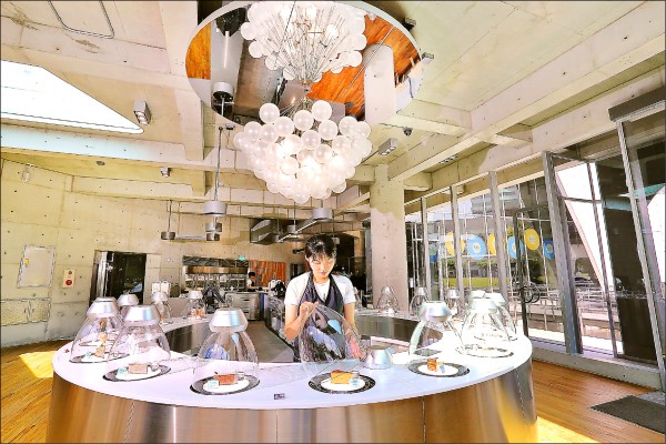 深藍咖啡館旗艦店為簡約時尚的清水模建築，室內以「圓」為主視覺，從展示冰櫃、燈具到遮光板等設計都呈現幾何圓形軌跡，搭配自然光影投射形成獨特風格。（記者李惠洲／攝影）