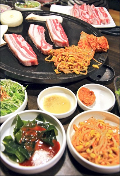 濟州島的黑豬肉一條街匯聚各種吃到飽燒烤店，燒烤的黑豬美味令人難忘。