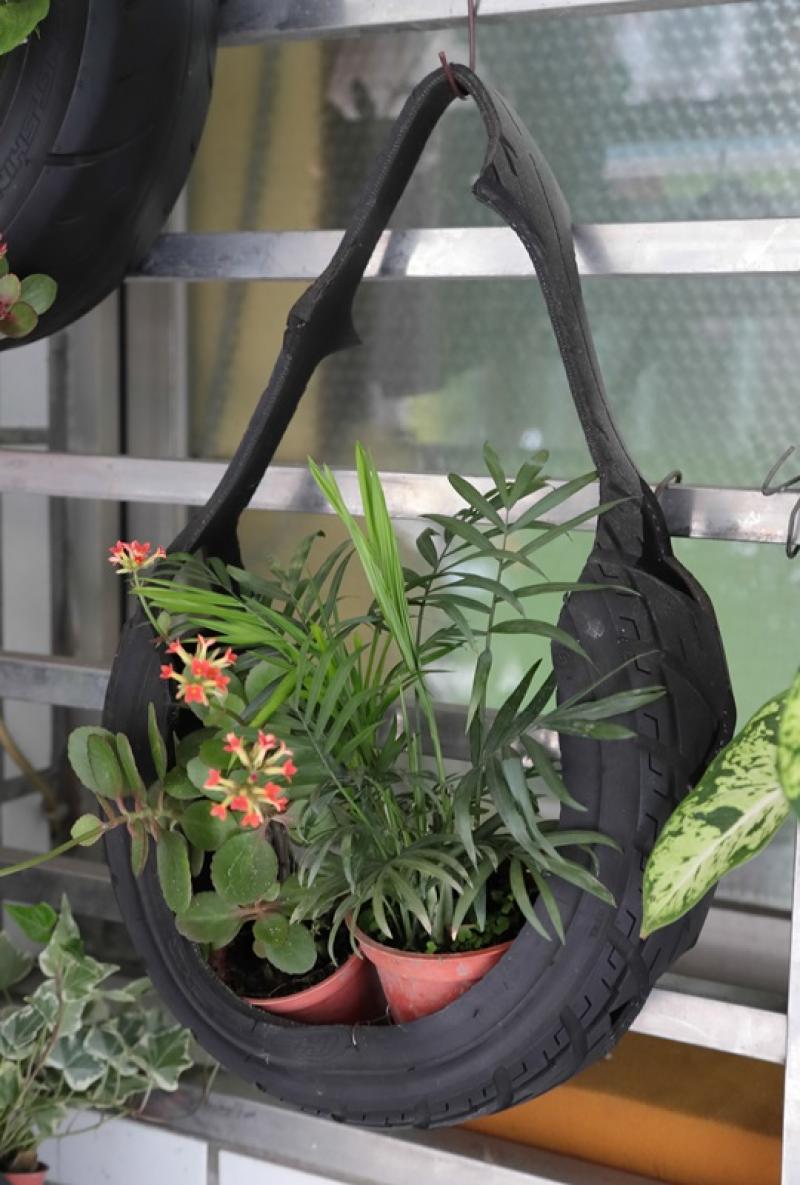 工作室外的掛飾品，掛滿各式植栽，不仔細看很難發現是由廢棄輪胎製成。（記者陳宇睿／攝影）