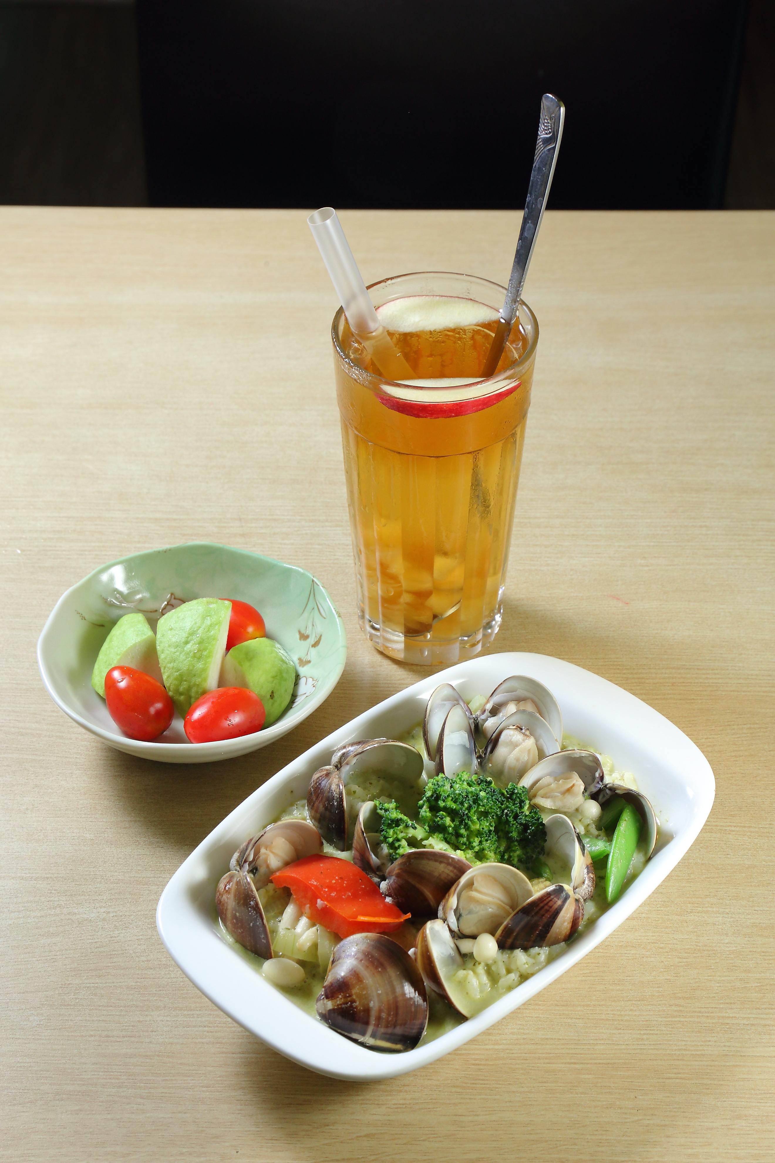 蛤蜊青醬燉飯／280元（前，附水果）、 蜂蜜蘋果茶／120元：青醬香醇濃郁，燉飯粒粒分明，料多實在。蜂蜜蘋果茶甜度適中，散發蜂蜜與蘋果香氣，清新爽口。（記者李惠洲／攝影）