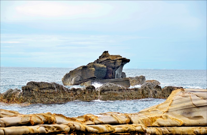 沿著海岸線自溪仔口往烏石鼻步行，沿途欣賞奇形怪狀的海蝕地形，至烏石鼻時，可見一隻大蟾蜍造型的海蝕岩佇立於海中。（記者許麗娟／攝影）