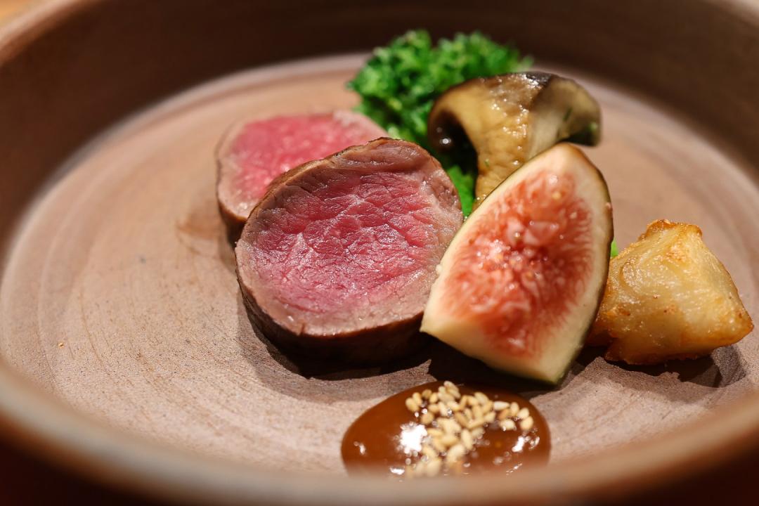「炭燒A5和牛菲力」以備長炭炭燒鎖住肉汁、使肉質軟嫩，搭配炸菊芋、天本菇、無花果等配料，再以特製日式味噌醬作為醬汁增香。（圖／記者郭宣暄攝）