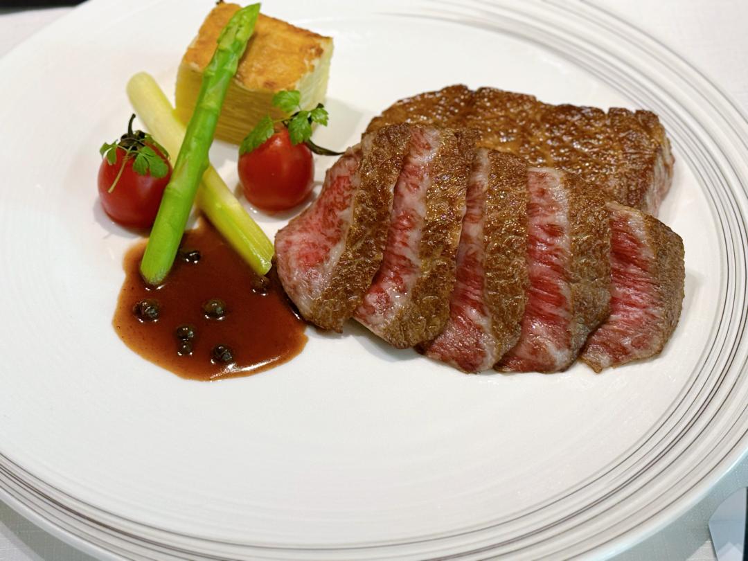 聯名限定主餐「日本A5和牛佐綠胡椒醬汁」，大理紋完美油花，炙烤後肉質外酥內嫩。（圖／記者郭宣暄攝）