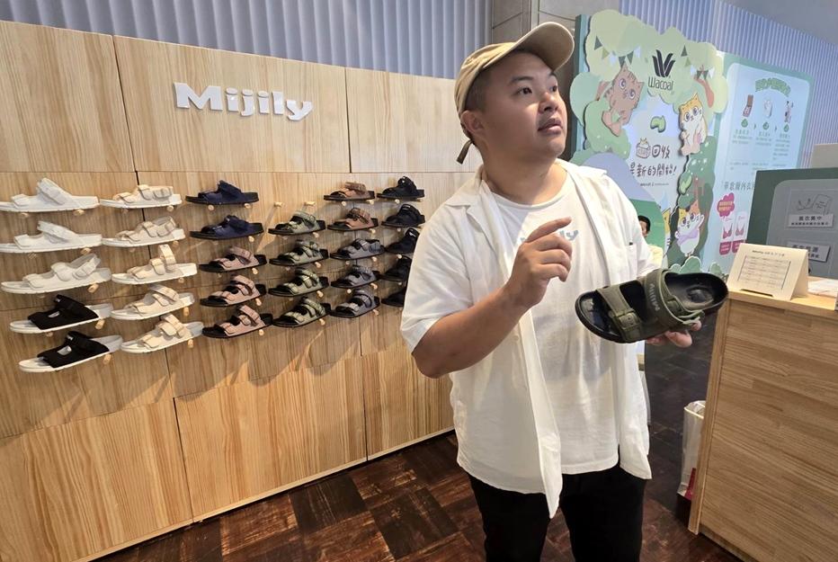 由陳鵬宏創立的米吉利（mijily），用回收寶特瓶與工業廢料製作可再生涼鞋，舊鞋可回收再製成花盆或鞋材，實踐封閉式循環設計。（圖／記者王捷攝）