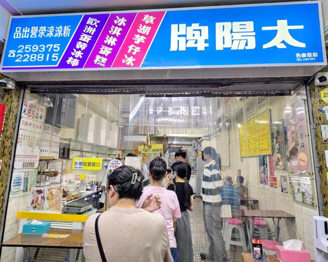 太陽牌冰品店門口排滿人潮，招牌左側有寫著「新涼涼」是太陽牌的前身，品牌可追溯到1957年。（圖／記者王捷攝）
