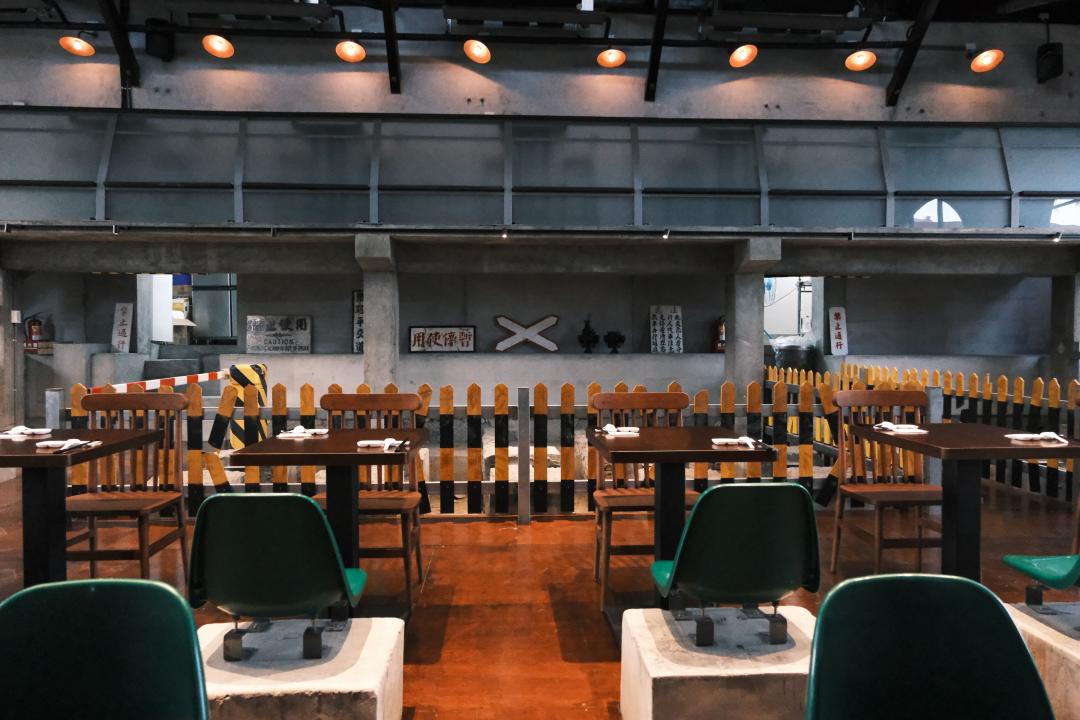 「機關車庫Tea House 1917」空間挑高，巧妙地利用修車水泥柱作為餐椅空間，更保留了修車溝的結構。（圖／業者提供）