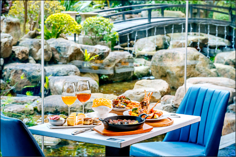 「青焰炭火熟成牛排」進駐台北美麗信花園酒店1樓，餐廳可容納約150席，窗外庭院水池與綠意相映，營造愜意的用餐氛圍。（路易莎餐飲集團提供）