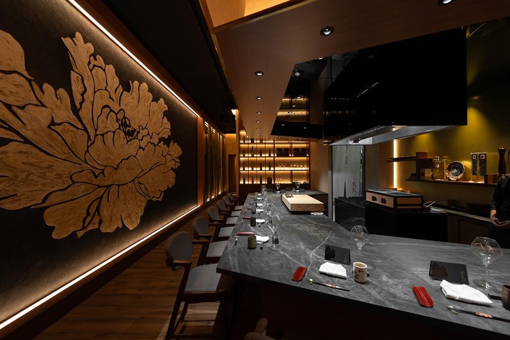 板前區另一偌大牆面以雷射切割木材製成的牡丹花為主題,牡丹素有「萬花之王」之稱,象徵尊貴與華麗。(圖/業者提供)