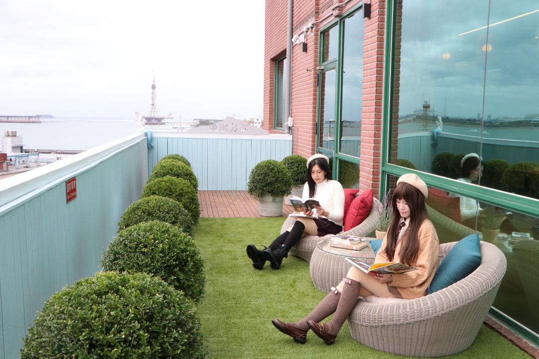 戶外露台打造成度假風景觀閱讀區，可以欣賞無敵河景與迷人夕陽，特別療癒。（圖／新北市政府提供）