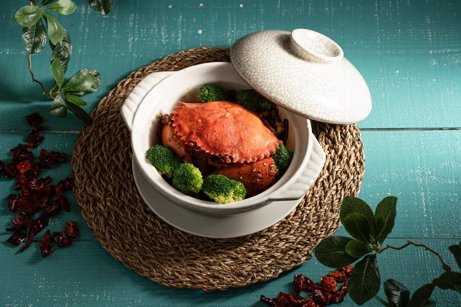 啫啫金不換焗蟹採粵式「啫啫煲」手法，端上桌仍冒熱氣作響，搭配九層塔提香，展現粵菜火候功夫。（圖／大員皇冠假日酒店提供）