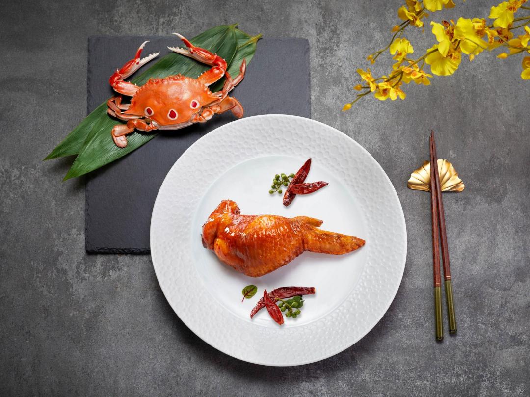 望月樓主廚邱龍俊設計的精緻粵菜「巴蜀。蟹肉。脆皮翅」，以蟹粉與蟹膏填入去骨雞翅，展現廣菜的「釀」技法精髓。（圖／台南遠東香格里拉提供）