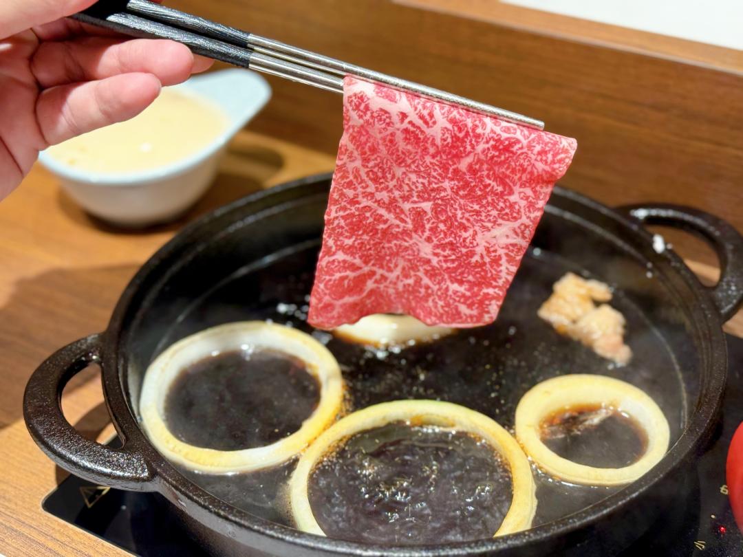 「牛喜」以和牛牛油丁、洋蔥熱鍋，撒上日本上白糖激發香氣，接著豪邁淋入特製壽喜燒醬汁。（圖／記者郭宣暄攝）