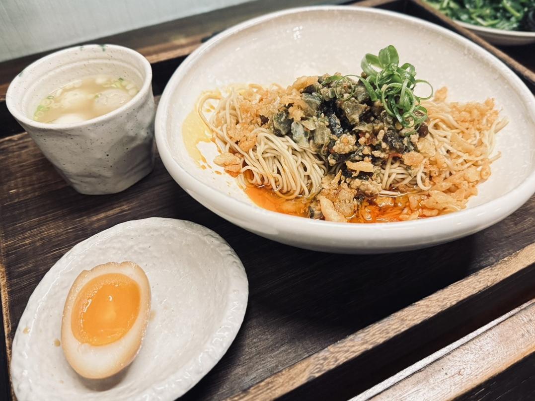 椒香皮蛋酥拌麵套餐有溏心蛋及魚丸雞湯、小菜，吃起來微辣爽口。