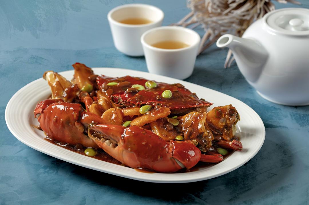 「醬爆沙公年糕」以Q彈年糕吸附醬汁和海味，襯托蟹肉的鮮嫩，展現上海菜濃油赤醬的特色，每份1,880元。