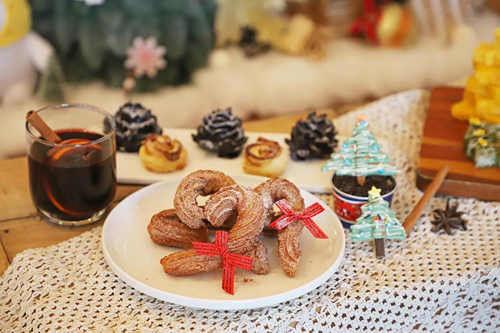 耶誕造型甜點與熱飲，甜甜圈、餅乾和棉花糖堆成童話角落，適合親子拍照打卡享甜蜜。（和逸飯店台南西門館提供）