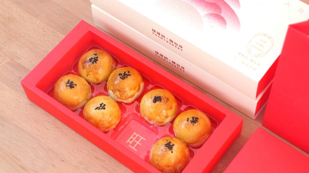 拿起一顆紅土蛋黃酥，就能看到隱藏在底下的「新春好日馬上旺」某個祝福字，帶來驚喜。（圖／品牌提供）