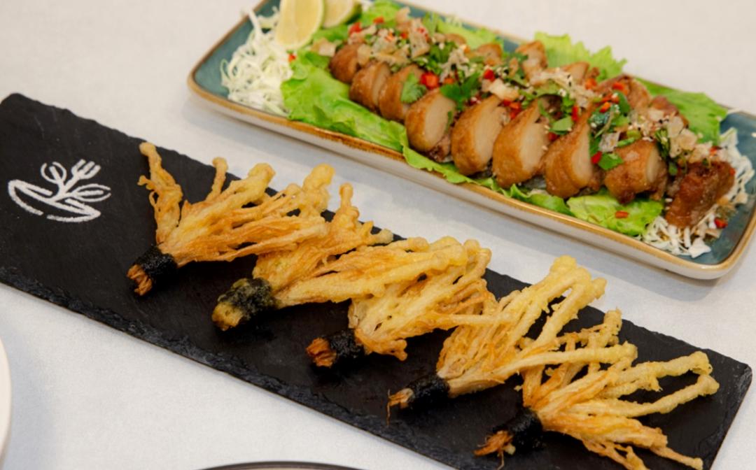 外觀如花朵盛開的「金針酥扇」(前)以及香辣開胃的「泰式椒麻酥排」。（品牌提供）