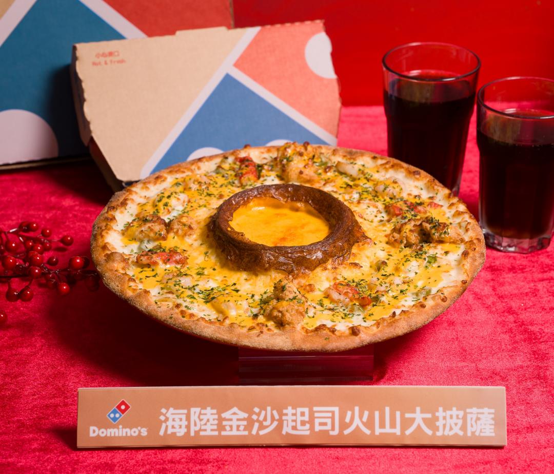 達美樂「海陸金沙起司火山披薩」以干貝、鮮蝦等多樣海鮮搭配酥脆炸雞，新春嘗鮮價499元。（品牌提供）