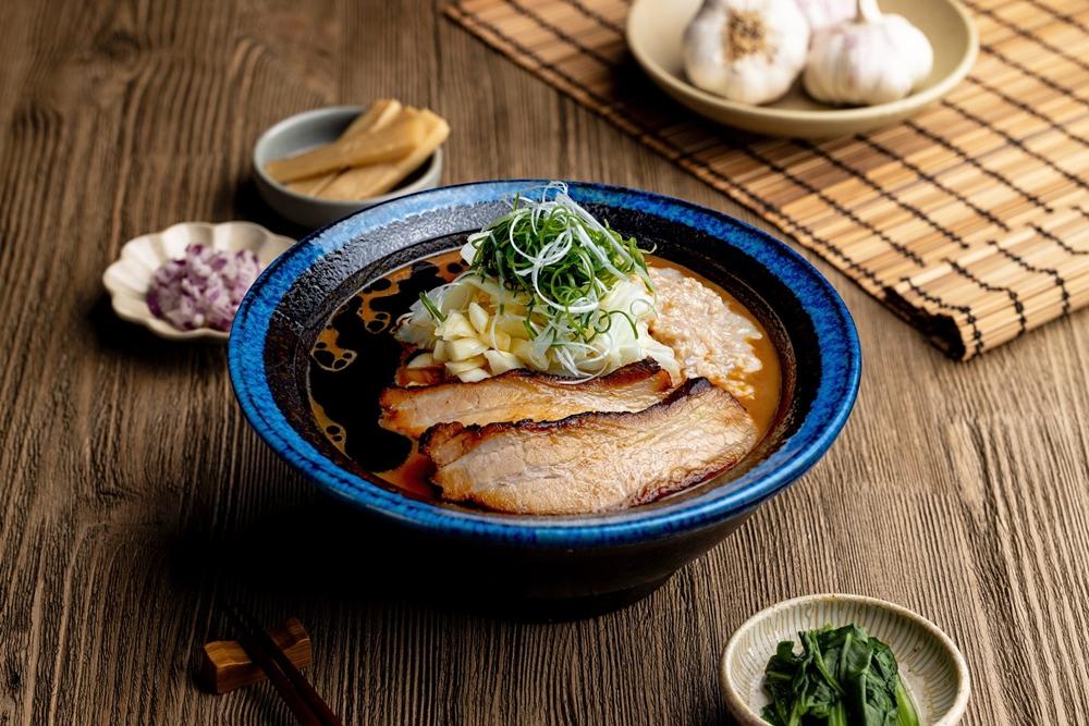 樂麵屋冬季限定「究極黑麻油蒜拉麵」以主廚秘製黑麻油的深焙香氣為基底，結合濃厚蒜香層層堆疊，湯頭入口即散發溫潤而醇厚的香氣。（品牌提供）