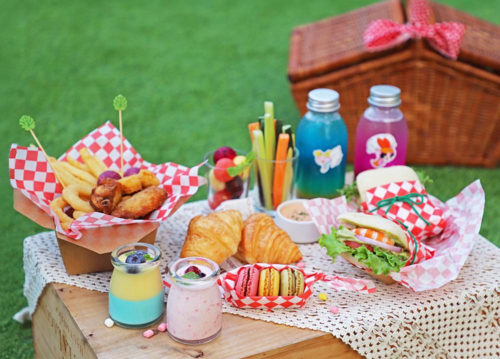 和逸飯店台南西門館推出飛天小女警雙人派對野餐籃，內含鮮蝦堡、炸物拼盤，與呼應角色色彩的飲品及甜點，為讓家長與孩童放心食用，都採用天然食材的顏色。（業者提供）
