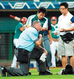 主審史考特遭球擊中，球賽被迫中斷。（記者黃志源攝）