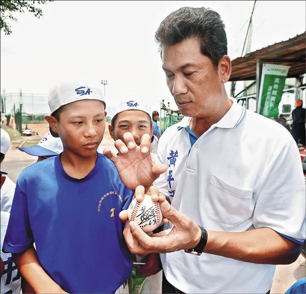 前職棒「金臂人」黃平洋特地到場替母校高市鼓岩國小學弟們加油,也指導擅長投蝴蝶球的高市陳維祥(左)其他變化球握法,並贈送小將們簽名球,讓小選手們又驚又喜。(記者林正堃攝) 前職棒「金臂人」黃平洋特地到場替母校高市鼓岩國小學弟們加油,也指導擅長投蝴蝶球的高市陳維祥(左)其他變化球握法,並贈送小將們簽名球,讓小選手們又驚又喜。(記者林正堃攝)