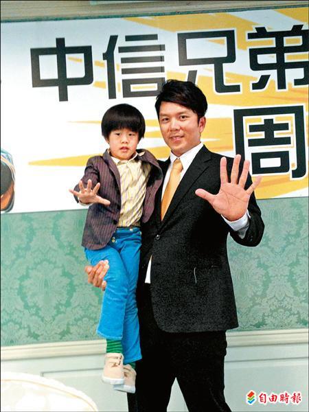 周思齊獲5年合約，抱著寶貝兒子周知樣一起比出5年。（記者倪婉君攝）
