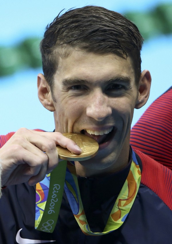 「飛魚」菲爾普斯(Michael Phelps)拿下金牌後開心的咬獎牌拍照。(路透) 「飛魚」菲爾普斯(Michael Phelps)拿下金牌後開心的咬獎牌拍照。(路透)