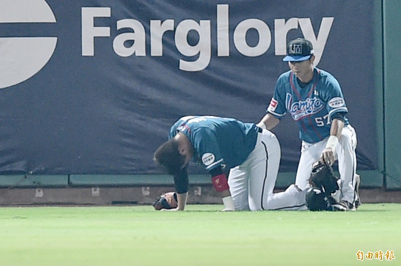 王柏融昨（左）接一記深遠高飛球重摔，久久不能站起來。（記者廖耀東攝）