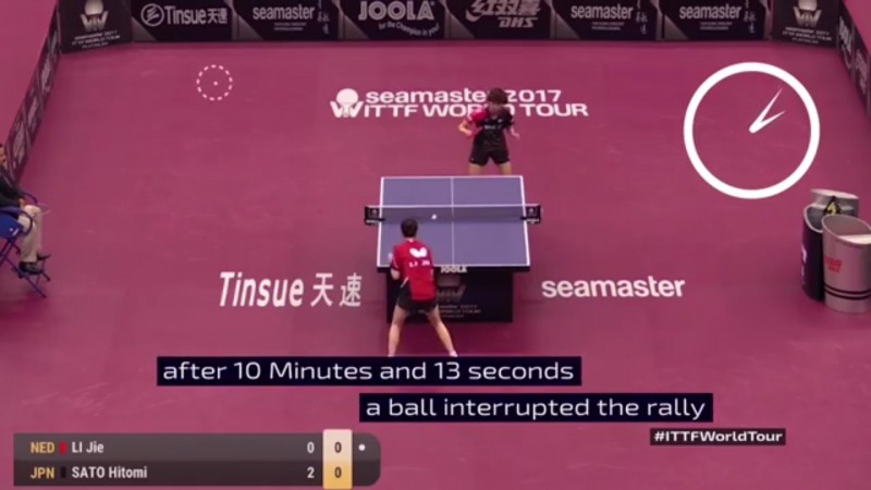 畫面左上方出現隔壁桌的球，兩人看似無止盡的回合才被迫停止。（取自影片）