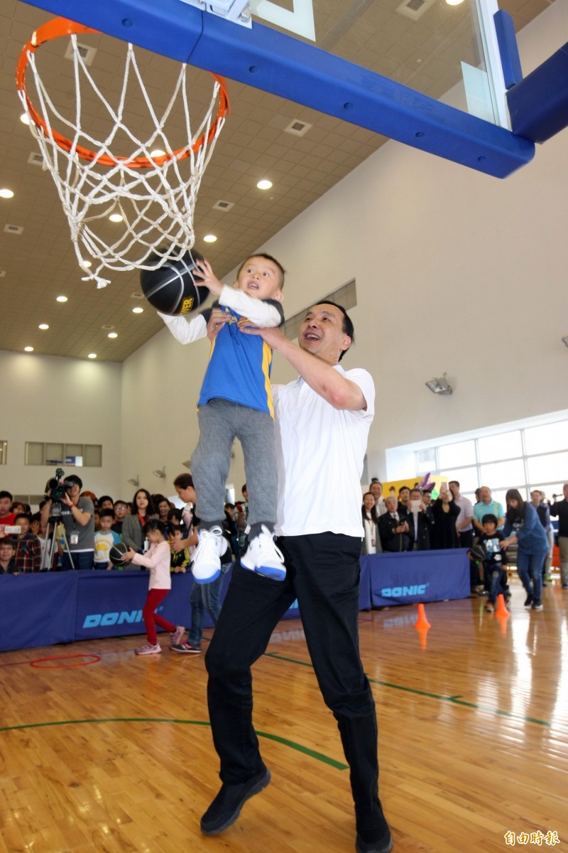 新北市市長朱立倫抱著達欣教練范耿祥的兒子灌籃。（新北市政府 體育處提供）