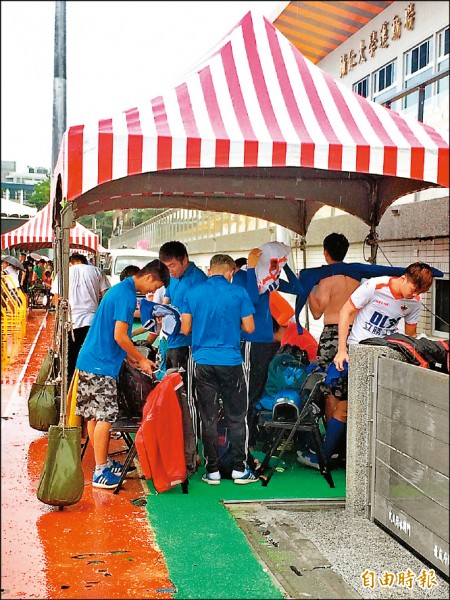 球員休息室及觀眾席未開放，導致選手在下雨天只能在場邊帳棚下換衣服。（記者廖聿偉攝）