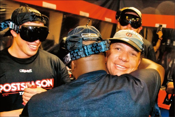 雙城隊老投手柯隆（右）與隊友擁抱慶祝晉級季後賽。（法新社）