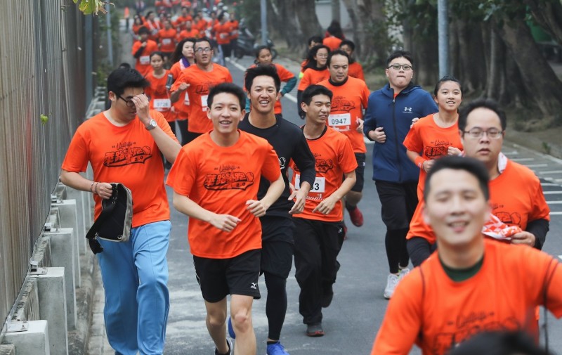 蘇智傑（中穿黑衣者）和球迷邊跑邊聊。（統一獅提供）