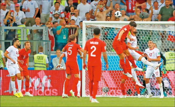 英格蘭昨在傷停補時靠後衛馬奎爾（右三）高高躍起爭球，順勢把球頂給凱恩（左二），聯手絕殺突尼西亞。（美聯社）