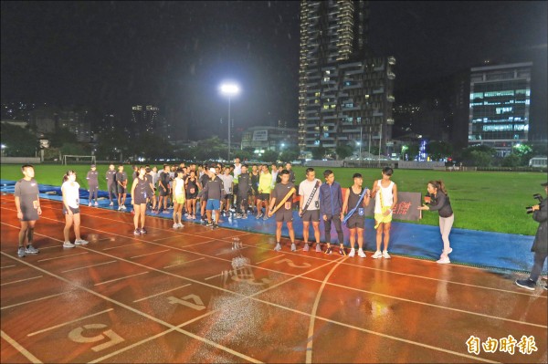 大迫傑（右四）不畏風雨，和台灣學生一同參與接力競賽。（記者卓佳萍攝）