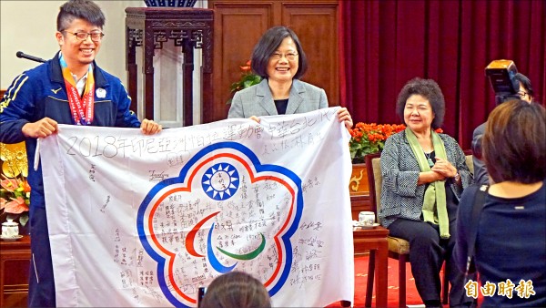 總統蔡英文（左2）昨日接見台灣亞帕運代表團，與團員簽名的會旗合影。（記者叢昌瑾攝）