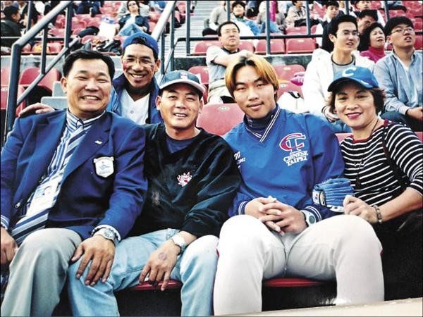2002年釜山亞運，染金髮的郭泓志（右二）和媽媽、陳献榮教練合影。（陳献榮提供）