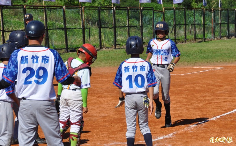 第六屆花蓮台彩威力盃少棒賽，新竹市江禮恩（右）擊出生涯首轟，跑回本壘時受到英雄式歡迎。（記者徐正揚攝）