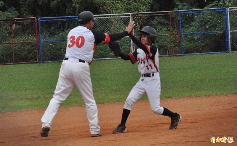 4強賽新北市對高雄市，劉承佑（右）1局下率先敲安並趁失誤直攻二壘，與總教練張耀騰開心擊掌。（記者徐正揚攝）