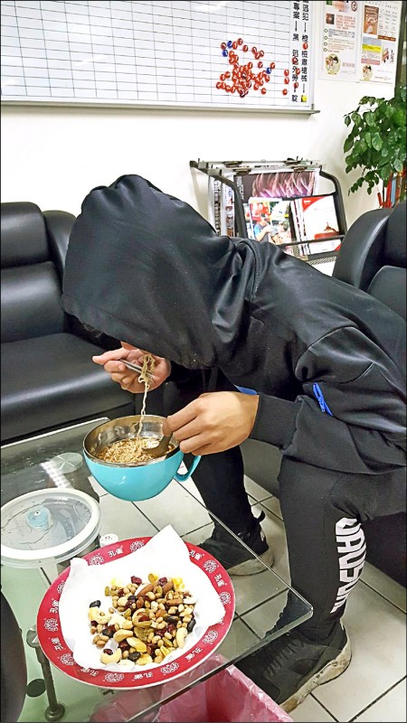張勝翔今年初蹺家兩個月後被尋獲，在高市警局悶著頭吃泡麵。（資料照，記者黃良傑翻攝）