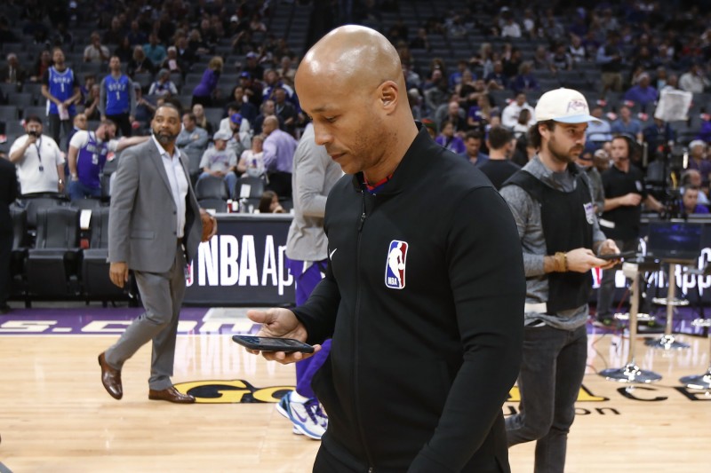 NBA在今年3月11日時宣布無限期延賽，圗為當時裁判利用手機接收停賽消息。（資料照，美聯社）