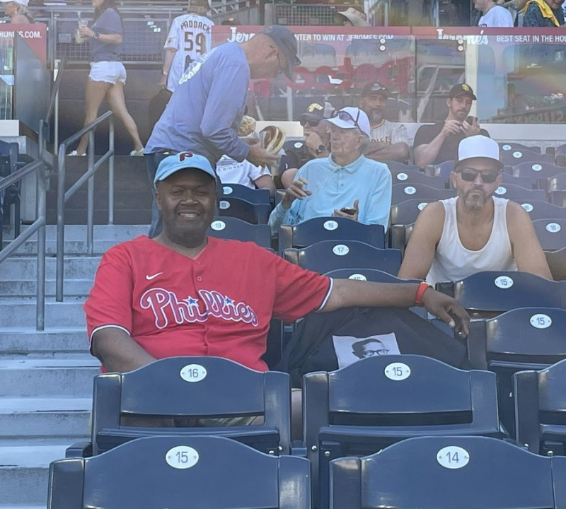 費城人球迷克勞利帶著因癌症病逝的父親一同看球，在隔壁座位披上印有父親照片的上衣。（取自網路）