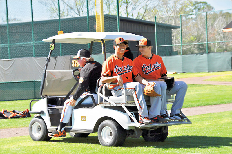 2013年效力金鶯的陳偉殷（中），春訓時搭總教練休瓦特（左）的順風車換場。（資料照）