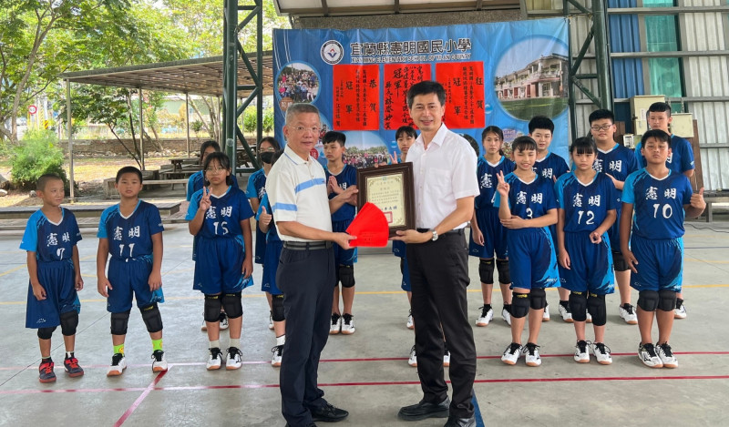 三星鄉長李志鏞（前排左）今天頒給憲明國小躲避球隊獎勵金，由校長王信義（前排右）代表受贈。（圖由三星鄉公所提供）