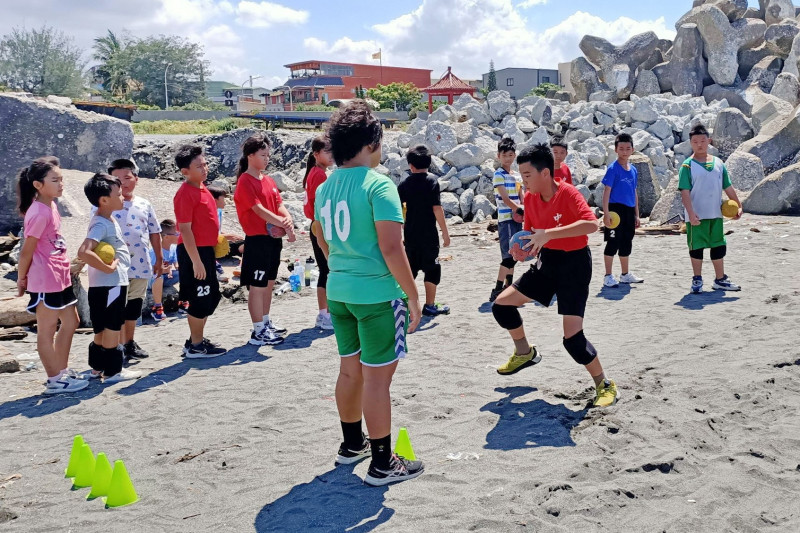學員在沙灘上打手球，對體力、耐力都是考驗。（中芸國小提供）