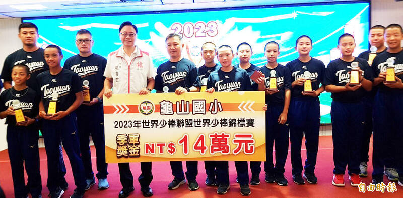 桃園市長張善政（左4）頒發獎勵金14萬元的季軍獎金給龜山國小少棒隊。（記者李容萍攝）