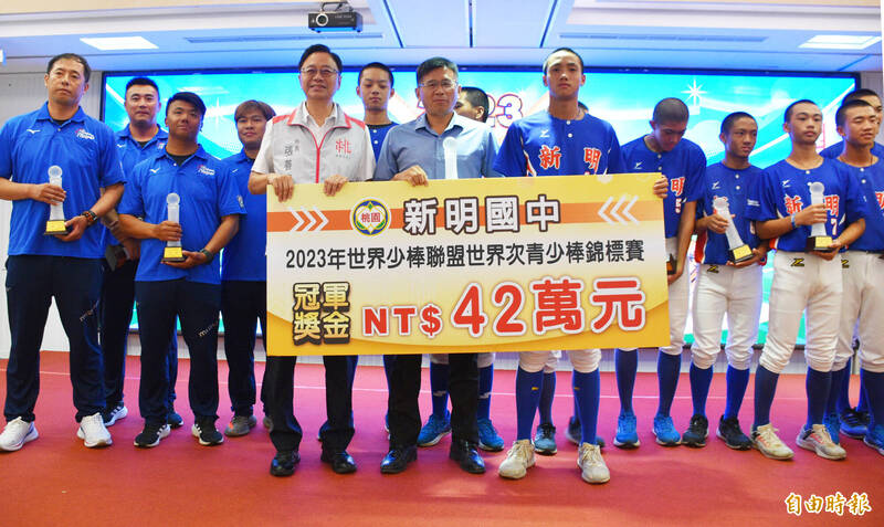 桃園市長張善政（前左）頒發獎勵金42萬元的冠軍獎金給新明國中青少棒隊。（記者李容萍攝）