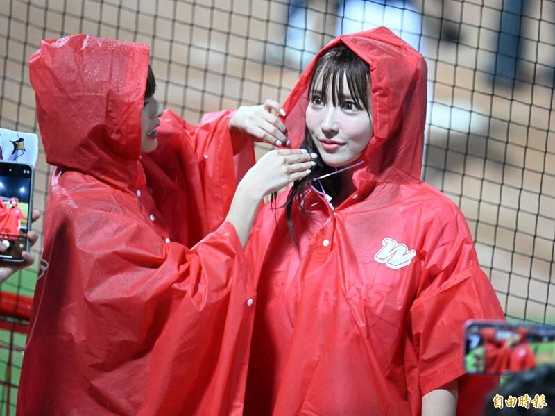 三上悠亞穿上雨衣幫味全龍應援。（記者王藝菘攝）