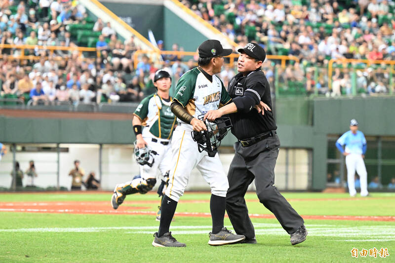 洪一中總教練抗議漏踩壘包，衝上去與主審裁判發生推擠衝突。（記者李惠洲攝）